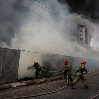 Bombeiros ucranianos lutam para controlar incêndio em um armazém, em Kiev.