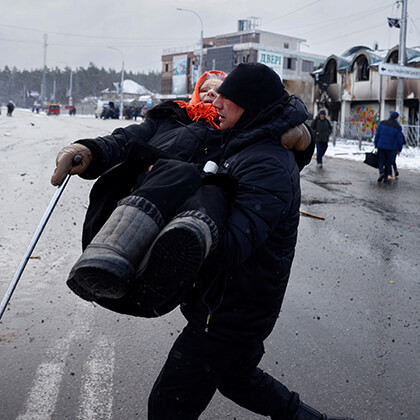 Uma homem ajuda uma idosa na retirada.