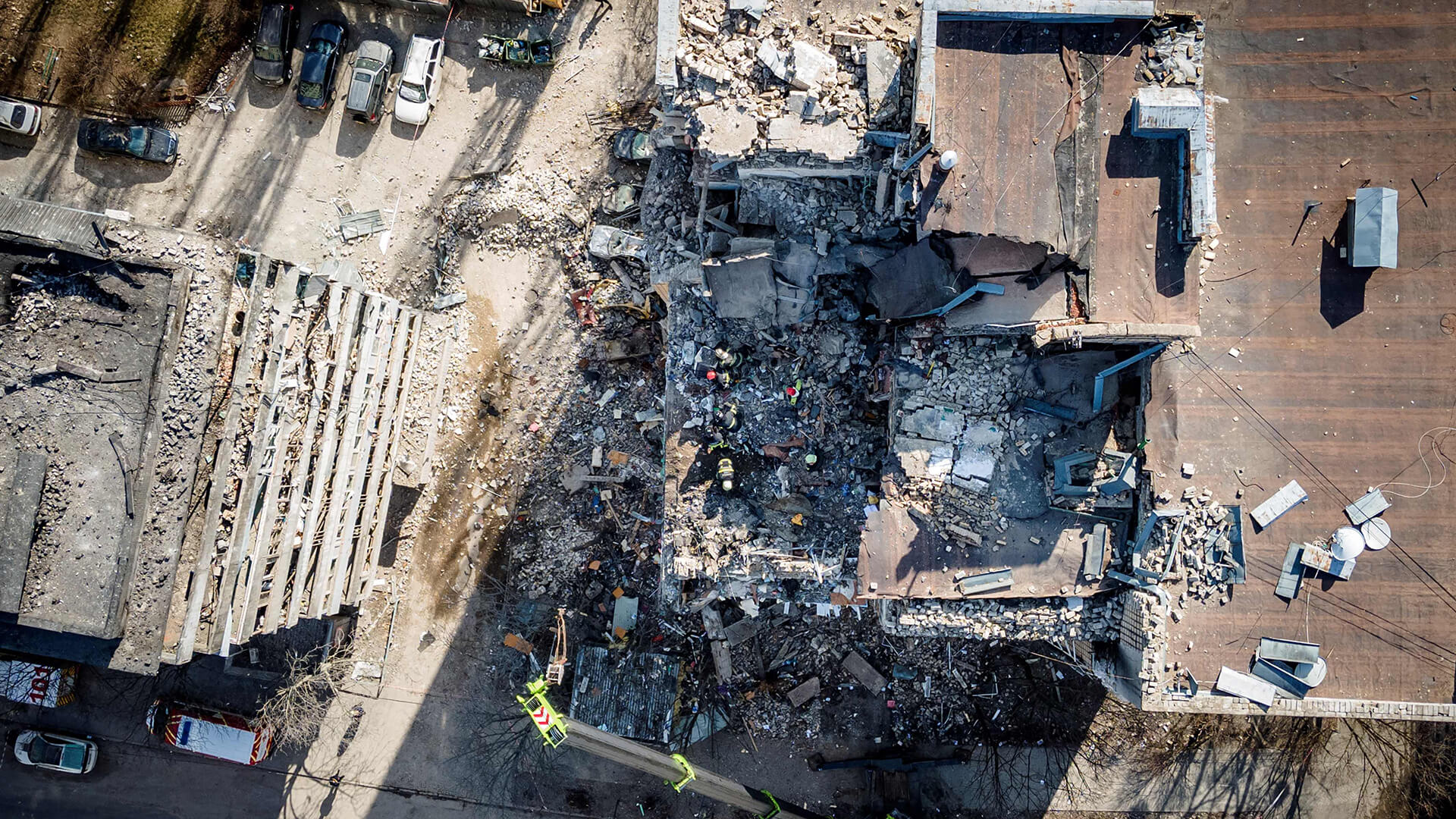 Bombeiros buscam vítimas nos escombros de um prédio residencial atingido por destroços de um foguete, em Kiev.